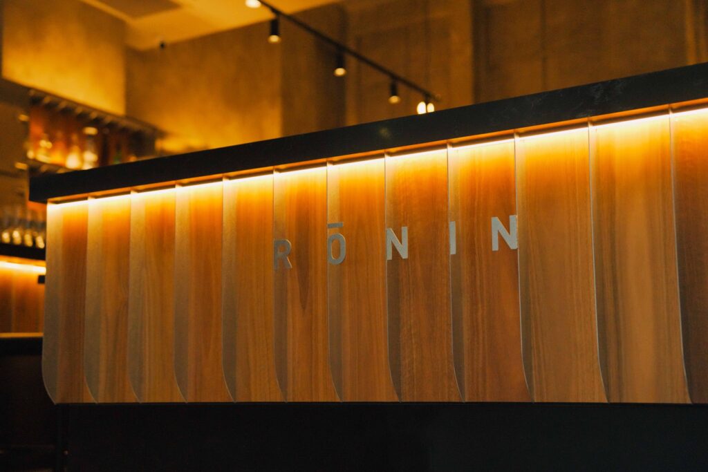 Rōnin name cut into the backlit timber bar front
